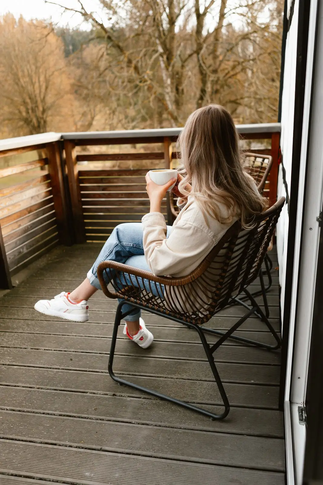 Doppelzimmer: Gast sitzt mit einer Tasse Kaffee auf dem Balkon