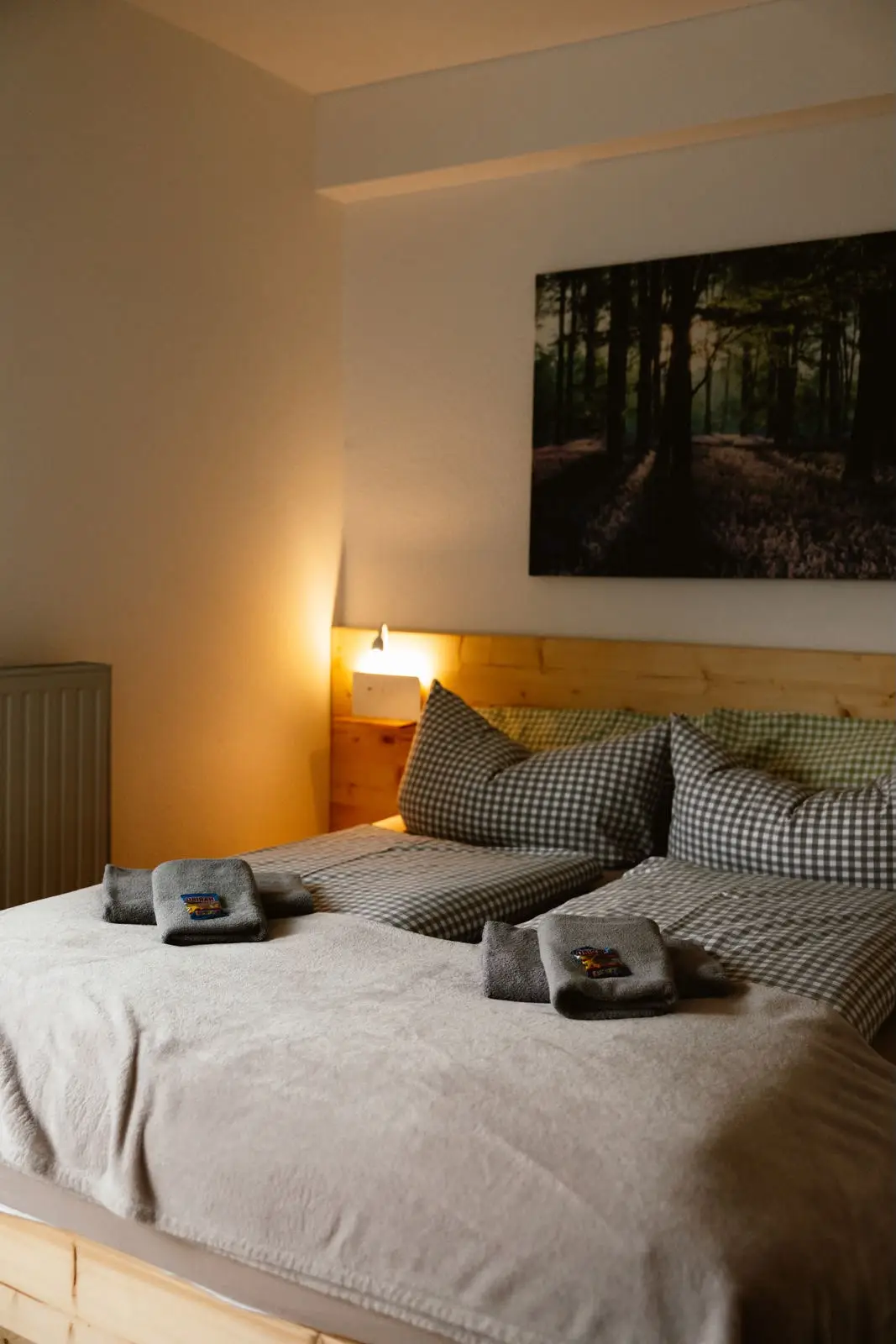 Kleines Doppelzimmer: Bett von der Seite mit bereitgelegten Handtüchern
