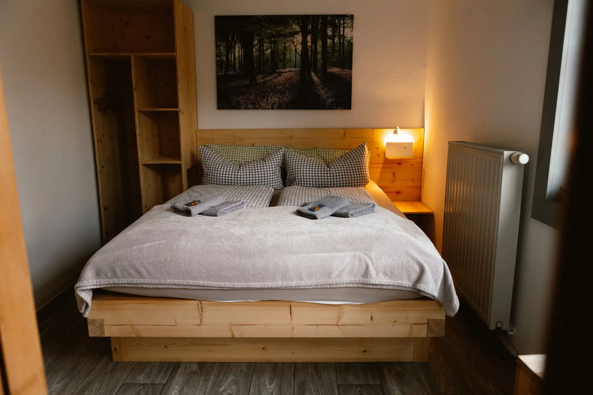 Kleines Doppelzimmer: Massivholzbett mit Kleiderschrank und warmer Leselampe