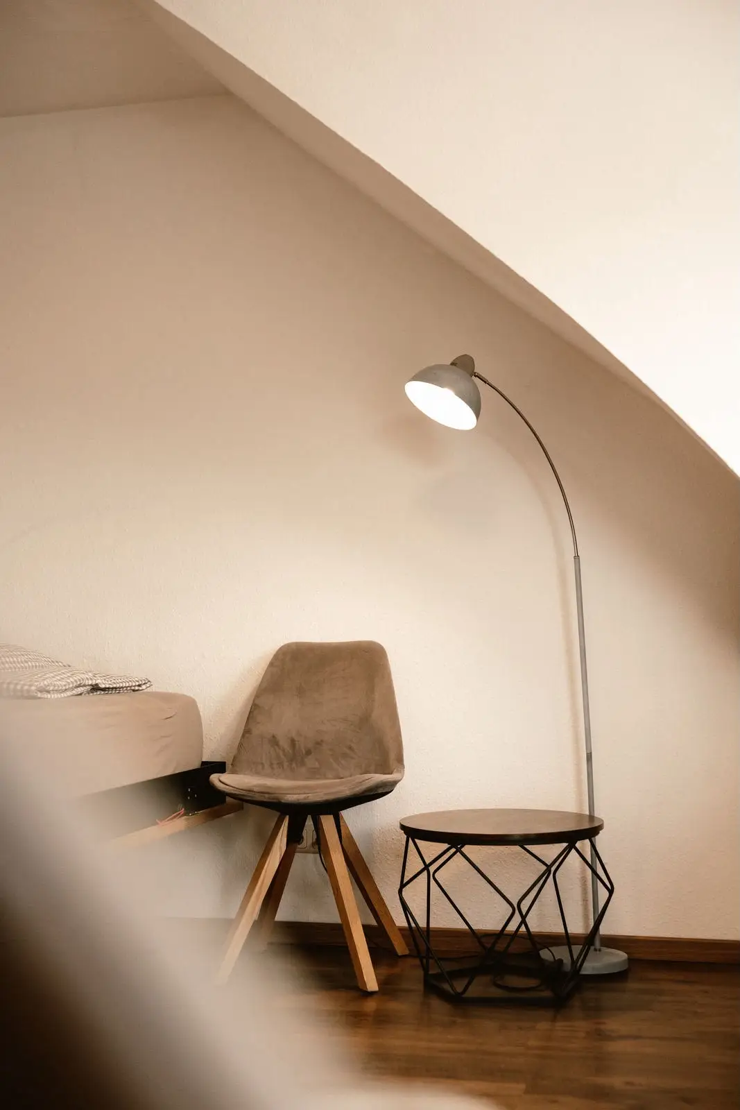 Familien-Suite: Leseecke mit Sessel und Bogenlampe unter der Dachschräge