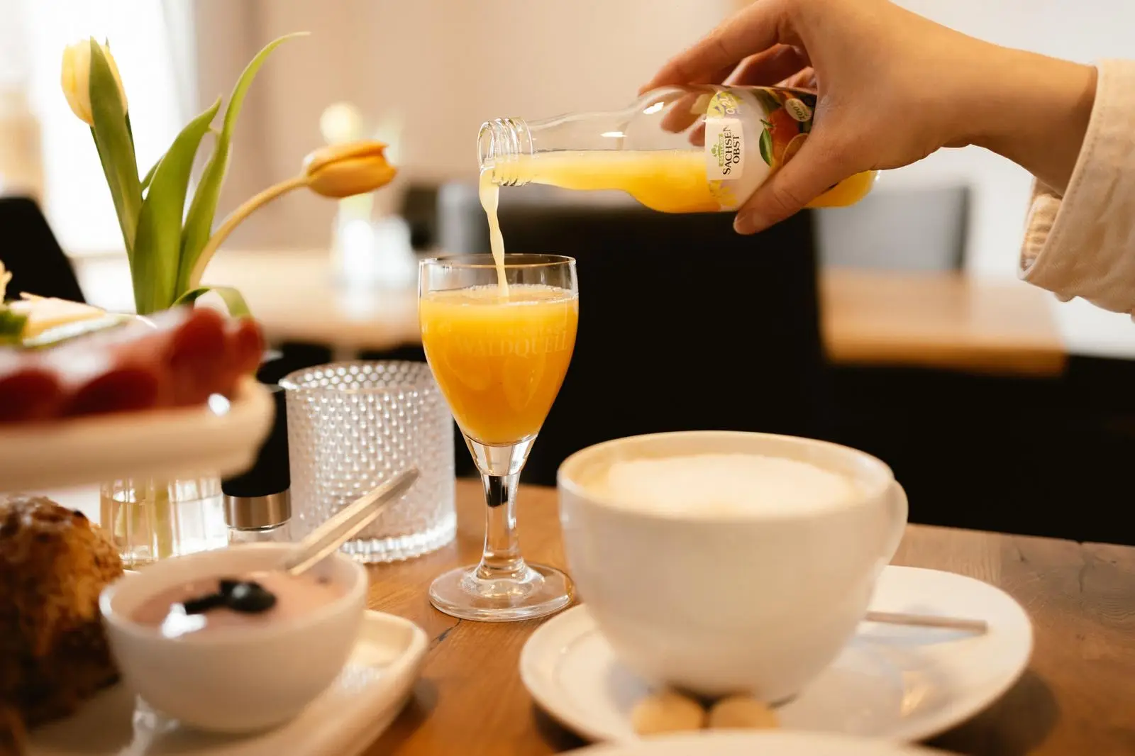 Frisch eingeschenkter Orangensaft zum Frühstück